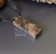 a piece of wood that has been carved into a pendant on a cord with the word ebroah written below it