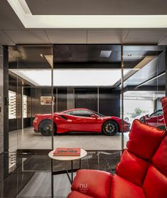 two red sports cars in a showroom with glass walls