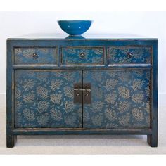 an old blue cabinet with a bowl on top