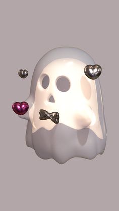 a white mask with black bow ties and hearts on it's nose is floating in the air