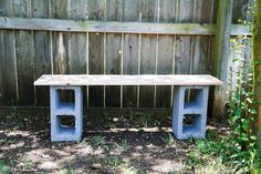 a wooden bench sitting in the grass next to a fence