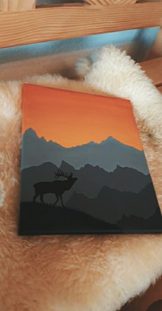 a book with an image of a deer on it sitting on top of a bed