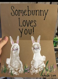 someone is holding up a card with two rabbits painted on it that says, somebunny loves you