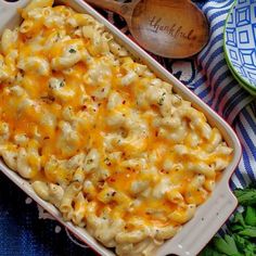 a casserole dish filled with macaroni and cheese on a blue cloth