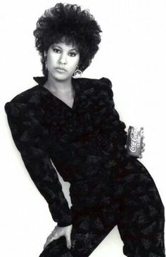 a black and white photo of a woman with an afro haircut wearing a suit