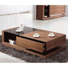 a wooden coffee table with two cups on top and one drawer open in the middle