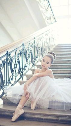 a young ballerina sitting on the stairs