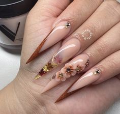 a woman's hand with long, shiny nails and flowers on it