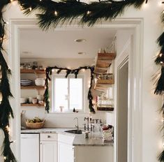 a kitchen decorated for christmas with garland and lights