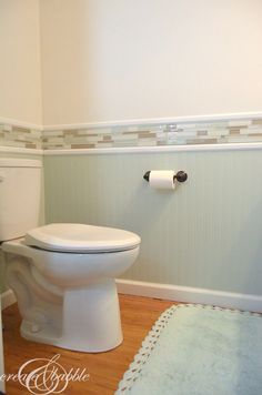 a white toilet sitting in a bathroom next to a wall