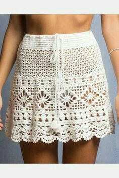 a woman wearing a white crochet skirt