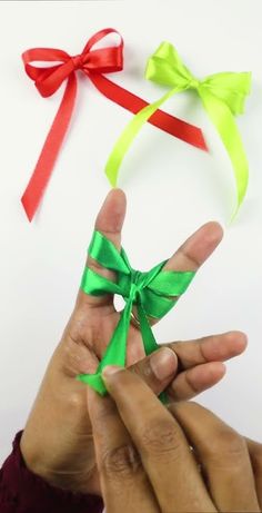 two hands are holding ribbons in different colors