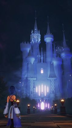 a woman standing in front of a castle at night