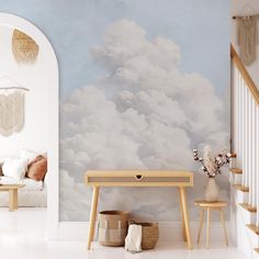 a living room with clouds painted on the wall next to a table and two stools