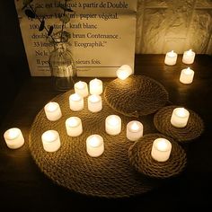 many lit candles sitting on top of a table next to a sign with words written in french