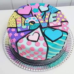 a colorful cake with hearts and letters on it