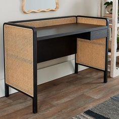 a black desk with wicker drawers and mirror on the wall in front of it