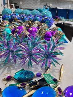 some blue and purple items sitting on a white table with other things in the background