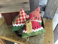 two decorative pillows sitting on top of a wooden table next to a basket filled with fruit