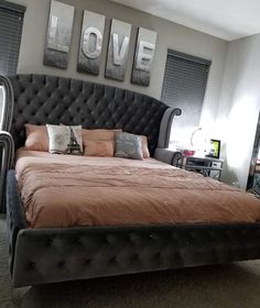 a large bed sitting in a bedroom next to two pictures on the wall above it