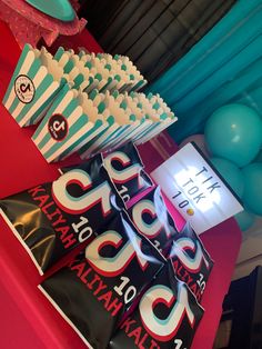 a table with blue and white striped paper cups, popcorn boxes, and balloons on it