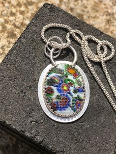 This stunning cabachon is from the 1920's it's made using traditional millefiori glass that is then pressed into a mould before cooling. This gives the snakeskin appearance. A small amount of uranium is also added before cooling Glass Cabochon Pendant Jewelry, Handmade Glass Flower Pendant Necklaces, Glass Pendant Necklace With Cabochon, Handmade Multicolor Oval Cabochon Jewelry, Handmade Multicolor Jewelry With Oval Cabochon, Handmade Oval Czech Glass Jewelry, Traditional Oval Cabochon Necklace, Traditional Oval Cabochon Necklaces, Artisan Glass Pendant Necklace