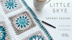 a crochet coffee cup sits on top of a table next to a mug