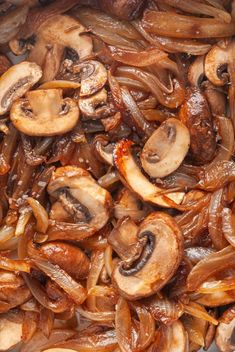 mushrooms and onions cooking in a pan on the stove