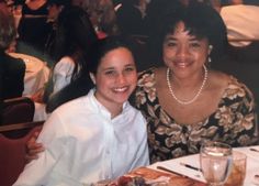 two women sitting next to each other at a table