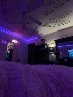 a bedroom with purple lighting and a large bed