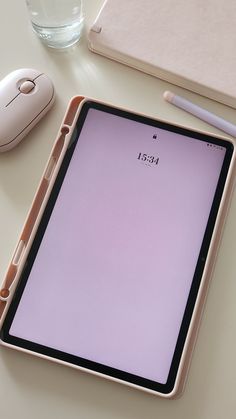 an ipad is sitting on a desk next to a mouse