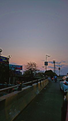 cars are driving down the road at dusk