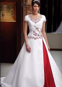 a woman in a white and red wedding dress standing on the floor with her hand on her hip