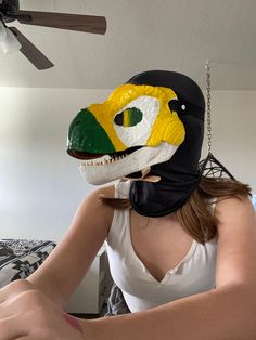 a woman wearing a mask with an alligator's head on it