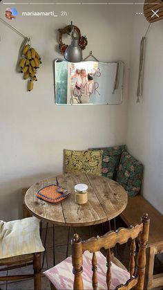 a wooden table and two chairs in a small room with a mirror on the wall