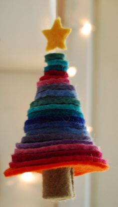 a multicolored christmas tree is hanging from a string with lights on it and a star in the top