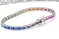 Here we have a beautiful and exquisite multi-color simulated sapphire tennis bracelet. All emerald cut gemstones are bezel set. There is an impressive 8 cts of weight of gemstones. The bracelet is 7-inches long and about 1/8-inch thick. This bracelet was designed to allure and impress with beautiful 14k white gold finish. It will be an excellent addition to a jewelry collection due to its uniqueness. Why spend thousands for the same look. The bracelet is made out of solid 925 Sterling Silver wit Multicolor Cubic Zirconia Tennis Bracelet For Formal Occasions, Formal Multicolor Cubic Zirconia Tennis Bracelet, Fine Jewelry Multicolor Cubic Zirconia Tennis Bracelet, Luxury Rainbow Cubic Zirconia Jewelry, Multi-stone Cubic Zirconia Tennis Bracelet As Gift, Elegant Rainbow Cubic Zirconia Jewelry, Silver Multi-stone Tennis Bracelet, Multicolor Cubic Zirconia Tennis Bracelet Gift, Elegant Rainbow Jewelry With Sparkling Stones