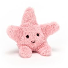 a pink teddy bear with black eyes and a star shaped nose sitting on the ground