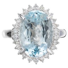 Mid-Century Bright blue clear oval aqua and diamond cocktail ring. This spectacular large 6.25ct oval aquamarine center stone is mounted in a handmade platinum setting with a 26 round brilliant cut diamond halo. Circa 1950-1960. 1 oval blue aqua, VS approx. 6.25cts 26 round brilliant cut diamonds, I SI I approx. .48cts Size 6.75 and sizable Platinum Stamped: PT 850 10.2 grams Width at top: 18.6mm Height at top: 9.7mm Width at bottom: 2.8mm Diamond Cocktail Ring, Diamond Cocktail Rings, Diamond Halo, Round Brilliant Cut Diamond, Cocktail Ring, Cocktail Rings, Halo Diamond, Bright Blue, Round Brilliant