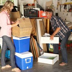 two people standing next to boxes in a garage