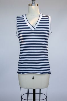 "A really cute vintage later 1970s to early 1980s tank top / sleeveless tee Stripped rib V neck, sleeveless, relaxed fit like a tee. Blue and off white stripes, soft knit, hem is left to roll. label: rrrrruss Fits like size: M Chest: 33-36\"   Length: 22\"   Condition: Excellent/very good. There is a very fain mark behind back shoulder. 9424" Floral Leather Jacket, Icelandic Wool Sweaters, Tan Tank Top, Knit V Neck, 1970s Dresses, Vintage Tank, Sleeveless Tee, Striped Tank Top, Top Sleeveless