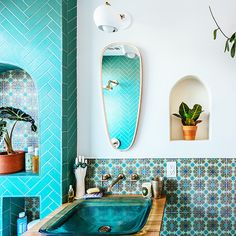 a bathroom with a sink, mirror and potted plants