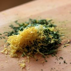 a pile of food that is on top of a cutting board with grated cheese