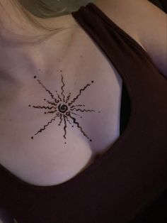 a woman's chest with a tattoo on it that looks like a spider web