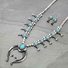 "Gorgeous Western Squash Blossom Turquoise Stone Necklace and Earring Set. Burnished Silver and Turquoise. Surgical Steel Ear Wires. Hypo Allergenic. Lead & Nickel Compliant. Necklace Length: 25\" With 3\" Extender. Lobster Claw Clasp. 3\" Pendant. Matching Earrings: 2\" with 1\" Drop. Add a Touch of Western Flair to Your Wardrobe."