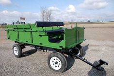 a large green trailer with a black seat on it's back end and wheels