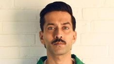 a man with a moustache on his face looking at the camera and making a funny face