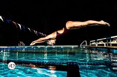 a woman diving into a pool at night