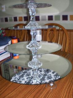 three tiered glass cake stand sitting on top of a wooden table