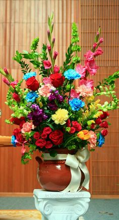 a vase filled with lots of colorful flowers